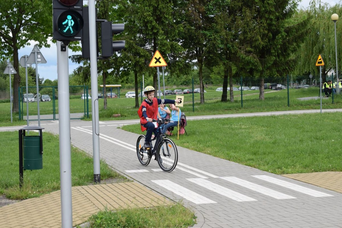 uczeń jedzie rowerem po miasteczku ruchu drogowego