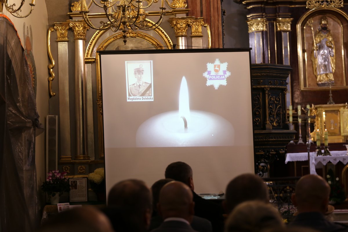 uczestnicy mszy św., w tle widać wyświetlaną prezentację na której znajduję się zdjęcie policjantki, która zginęła na służbie