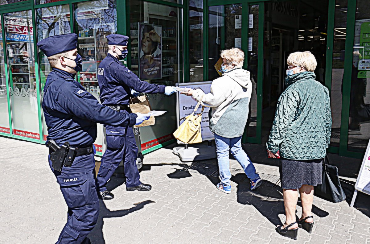 Policjanci rozdają maseczki.