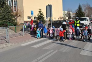 Dzieci pod okiem policjanta uczą się przechodzenia przez przejście dla pieszych