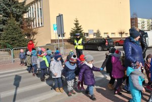 Dzieci pod okiem policjanta uczą się przechodzenia przez przejście dla pieszych