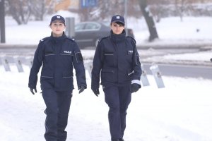 Dwie umundurowane policjantki idą ulicą w tle biały śnieg.