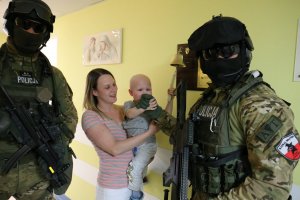 fot. zdjęcie kontrterrorystów z małym pacjentem i jego mamą