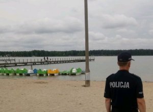 fot. lubartowski policjant na tle pomostu i jeziora w Firleju