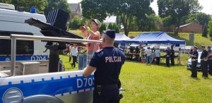 policjant pokazuje dzieciom pojazd służbowy