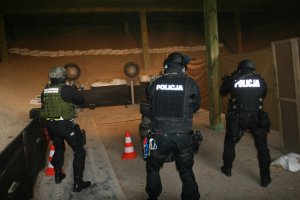 Policjanci Poddziału Kontrterrorystycznego strzelają do tarcz na strzelnicy..