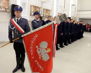 Poczet sztandarowy. Policjant prezentuje sztandar Komendy Wojewódzkiej Policji w Lublinie.