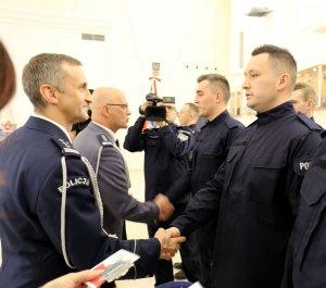 Komendant Wojewódzki Policji w Lublinie wraz z zastępcami wręcza legitymację nowym policjantom.