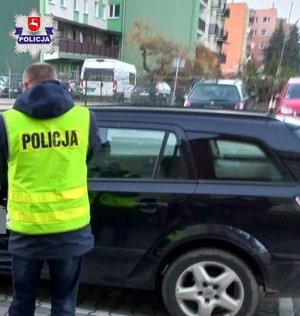 policjant przed samochodem